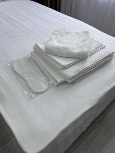 a pile of towels and plates on a bed at Velora Hostel in Khiva