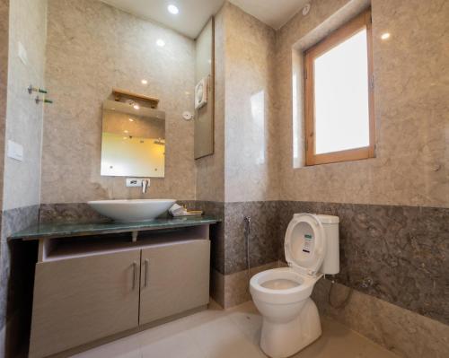 a bathroom with a toilet and a sink and a window at Indus County in She
