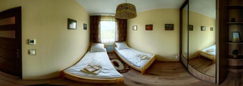 two beds in a room with a mirror at W Cieniu Akacji in Jaworki