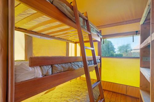 two bunk beds in a room with a yellow wall at Lodge La Forêt in Saint-Sauveur