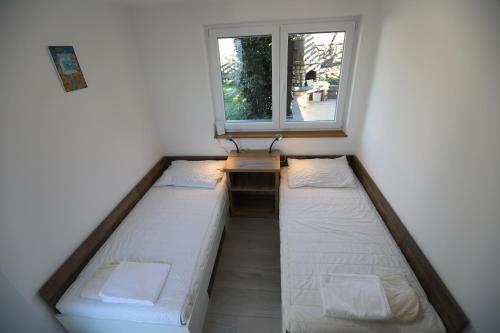 a room with two beds in front of a window at Apartman BARONI in Pinezici