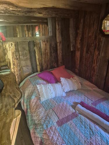 a small bed in a wooden cabin with at Cabane en Cévennes in Saint-Germain-de-Calberte
