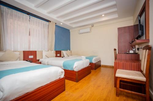 a hotel room with two beds and a television at Hotel AB Inn in Kathmandu