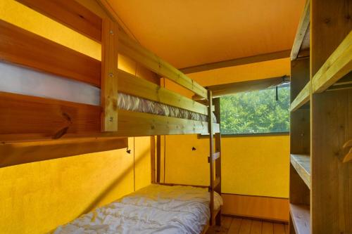 a bedroom with two bunk beds and a window at Lodge Les Étoiles in Saint-Sauveur