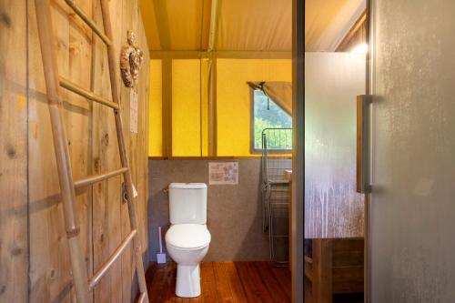 a bathroom with a toilet and a yellow wall at Lodge Les Étoiles in Saint-Sauveur
