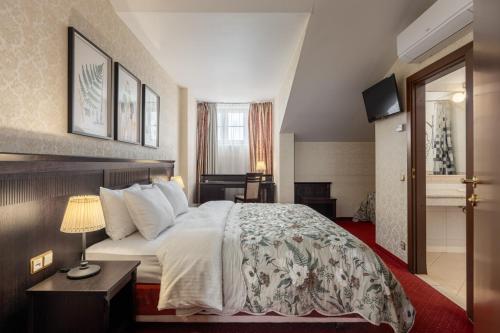 a hotel room with a bed and a television at Gertrude Hotel self check-in in Riga
