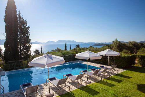 a swimming pool with lawn chairs and umbrellas at EOS Luxury Villa in Nydri