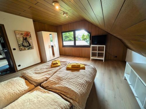 a bedroom with a large bed with two yellow towels on it at Ferienwohnung Mika in Bad Rothenfelde