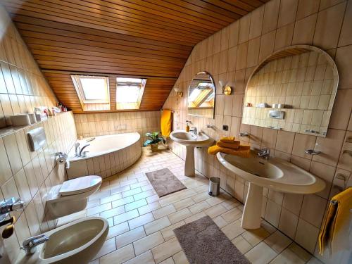 a bathroom with two sinks and a tub and a toilet at Ferienwohnung Mika in Bad Rothenfelde
