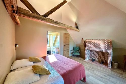 a bedroom with two beds and a brick fireplace at Maison proche Baie de Somme & Le Tréport-Terrasse in Biencourt
