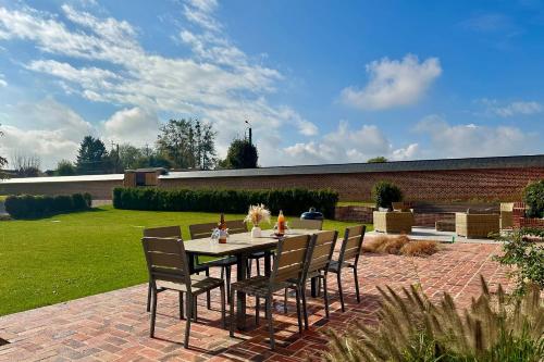 a table and chairs sitting on a brick patio at Maison proche Baie de Somme & Le Tréport-Terrasse in Biencourt