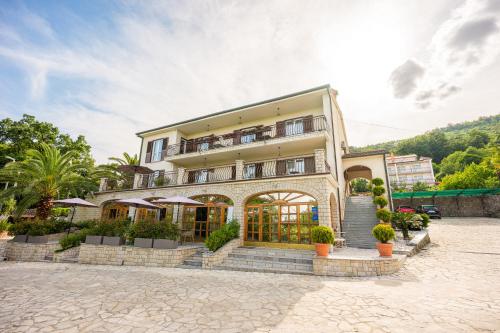 a large building with plants in front of it at Villa Klarić - Bed & Breakfast in Lovran