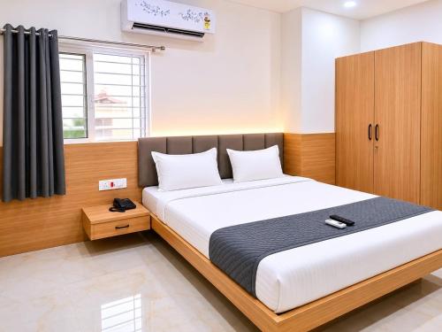 a bedroom with a large bed and a cabinet at Hotel Narsingi in Gundipet