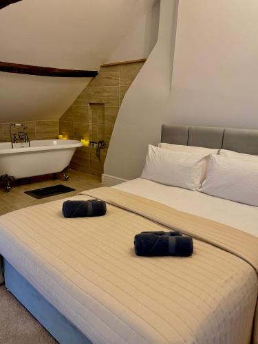 two beds in a room with a bath tub and a bed at Luxury Holt Duplex with Bath Suite in Holt
