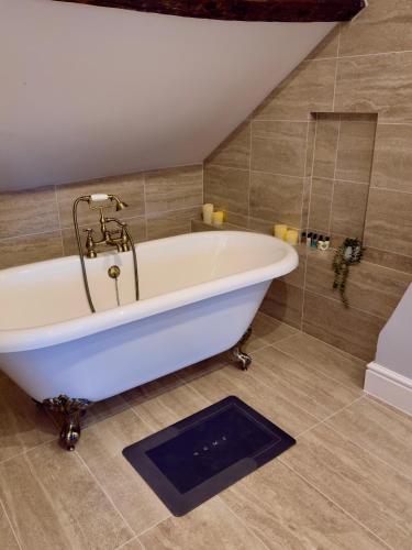 a white bath tub in a bathroom with a shower at Luxury Holt Duplex with Bath Suite in Holt