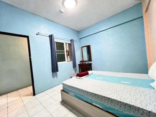 a bedroom with a bed and a blue wall at J Home Aonang in Ban Nong Chaeng