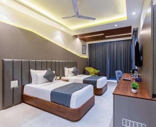 a hotel room with two beds and a television at S by Z Hotels, Baani Square in Gurgaon