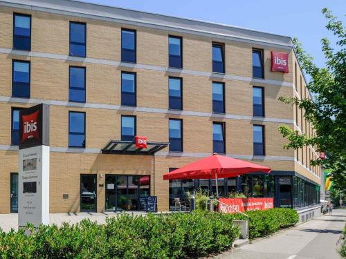 a building with a red umbrella in front of it at ibis Konstanz in Konstanz