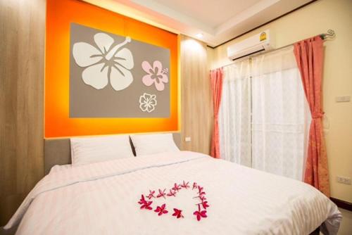 a bedroom with a bed with red flowers on it at Naphet Resort in Phetchaburi