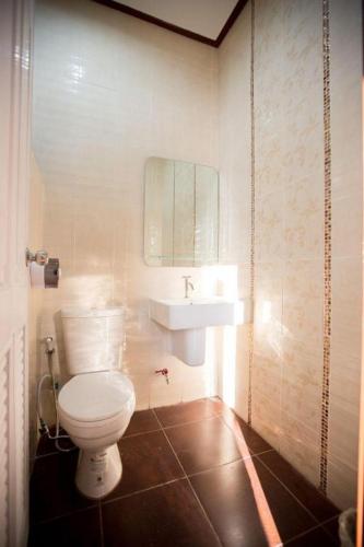 a bathroom with a white toilet and a sink at Naphet Resort in Phetchaburi