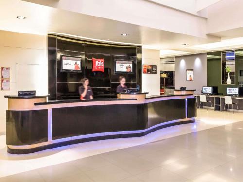 a cashier counter in a mall with two people at Ibis Bangkok Sukhumvit 4 in Bangkok