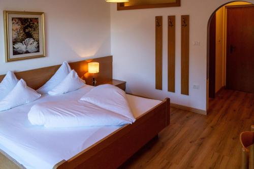 a bedroom with a large bed with white sheets and pillows at Garni An der Leit in Lagundo