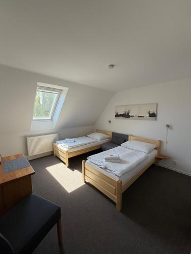 a room with two beds and a window at Penzion Laskala in Tišnov
