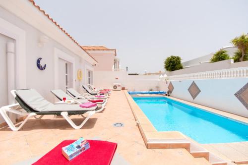 a pool with chaise lounge chairs and a swimming pool at Lovely 4 Bedroom Holiday Villa in Callao Salvaje