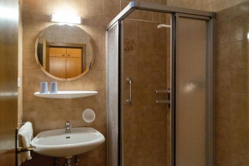 a bathroom with a sink and a shower with a mirror at Garni An der Leit in Lagundo