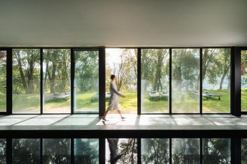 a woman walking in a building looking out of windows at Douro Palace Hotel Resort & SPA in Baião