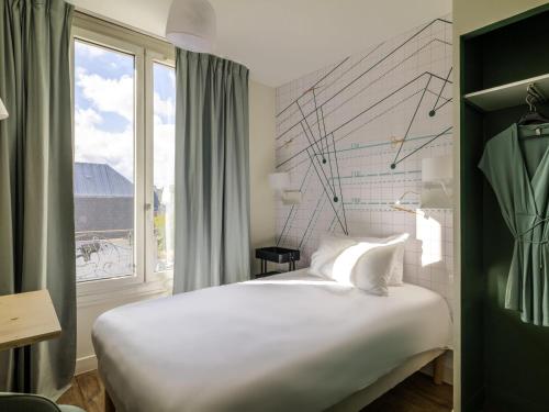 a bedroom with a large white bed and a window at ibis Styles Asnieres Centre in Asnières-sur-Seine