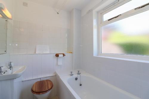 a bathroom with a tub and a toilet and a sink at Walk Farm Cottage in Gloucester