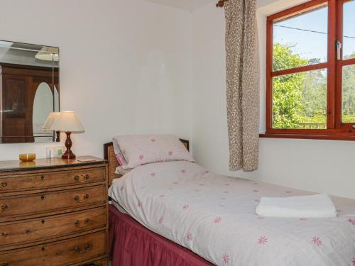 a bedroom with a bed and a dresser and a window at Walk Close in Gloucester