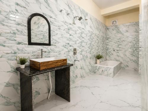 a bathroom with a stone wall and a sink and a tub at Guest House RK inn in Gorakhpur