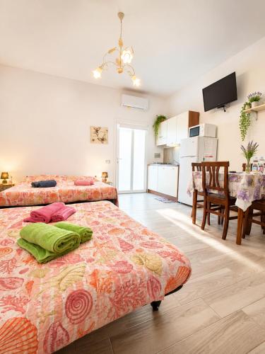 a bedroom with two beds and a kitchen with a table at Stella Marys Nord in Olbia
