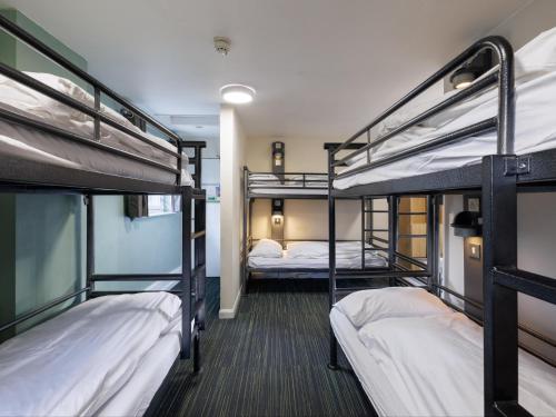 a dorm room with three bunk beds in it at YHA Castleton Losehill Hall in Castleton
