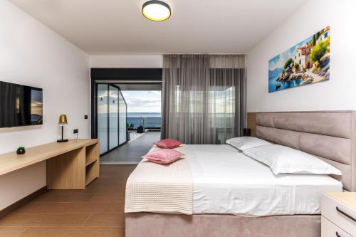 a bedroom with a large bed and a television at Stella Maris Deluxe in Podstrana