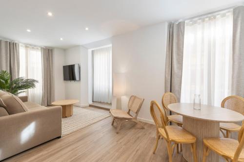 a living room with a couch and a table and chairs at BiBo Suites Casa Nawal in Granada