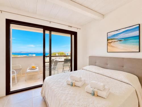 a bedroom with a bed and a view of the ocean at Renew Terrace RB Two Bedroom 50m from the Beach in Baja Sardinia