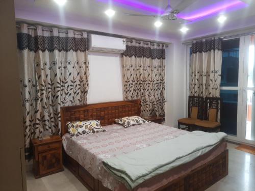 a bedroom with a bed and a window with curtains at Kaushal residency in New Delhi
