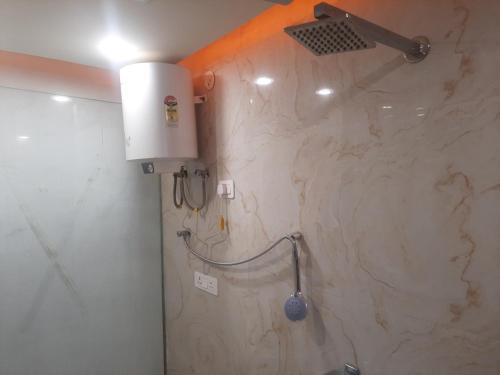 a shower in a bathroom with a marble wall at Kaushal residency in New Delhi