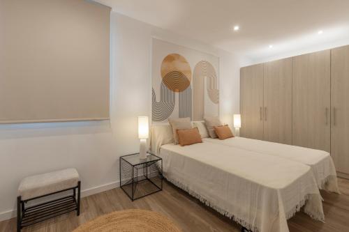a bedroom with a large white bed and a table at BiBo Suites Casa Nawal in Granada