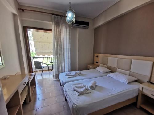 a hotel room with two beds and a window at Μπαλκόνι Στο Γαλάζιο in Agios Georgios