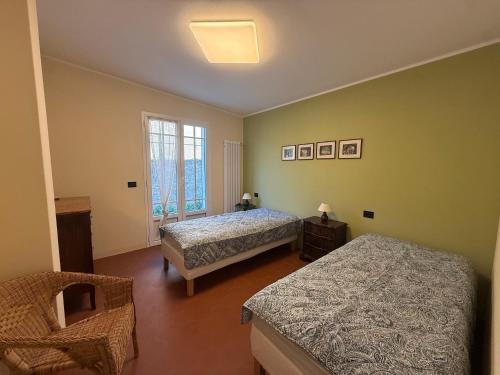 a bedroom with two beds and a window at Family villa con terrazza e relax in Pietra Ligure