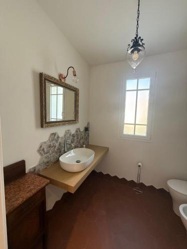 a bathroom with a sink and a mirror and a toilet at Family villa con terrazza e relax in Pietra Ligure
