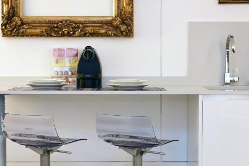 a counter with two chairs and a mirror at Sweet Apartment in Venice