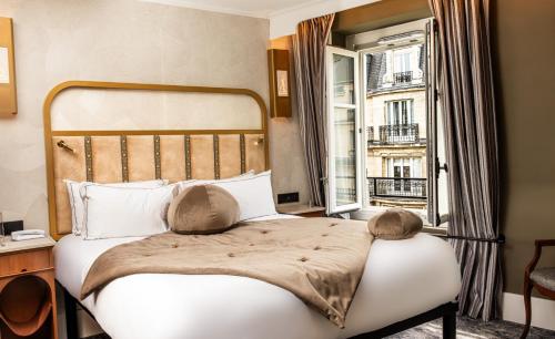 a bedroom with a bed with a large window at Hôtel BOHEM, Sacré-Cœur in Paris