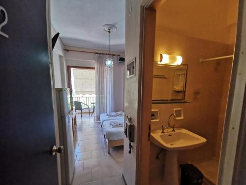 a bathroom with a sink and a room with a table at Μπαλκόνι Στο Γαλάζιο in Agios Georgios