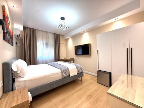 a hotel room with a bed and a tv at Prime Location - shared Bath in Tirana