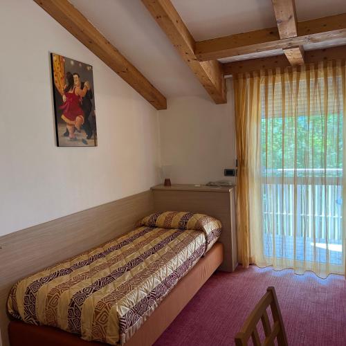 a bedroom with a bed and a window at Nature Bio Hotel Elite in Levico Terme